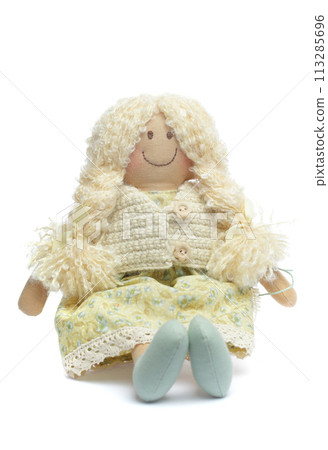 Soft doll with blonde hair isolated on white background. Soft doll with blonde hair isolated on white background. 113285696