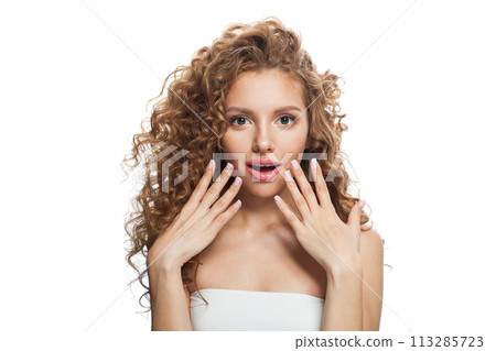 Shocked young woman with natural make-up, clear fresh skin and wavy hairstyle on white background Shocked young woman with natural make-up, clear fresh skin and wavy hairstyle on white background 113285723