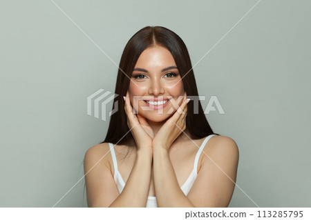 Healthy young woman brunette with long healthy hair and fresh silky skin posing on white background 113285795