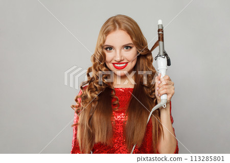 Attractive young glamorous woman with long straight and curly hair holding curling iron Attractive young glamorous woman with long straight and curly hair holding curling iron 113285801