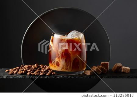 Iced coffee with cream on a black background. Iced coffee with cream on a black background. 113286013