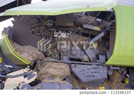 Tractor combine for straw baling inside clogged with debris dirt dust straw hay soil. Mechanism structure details 113286137