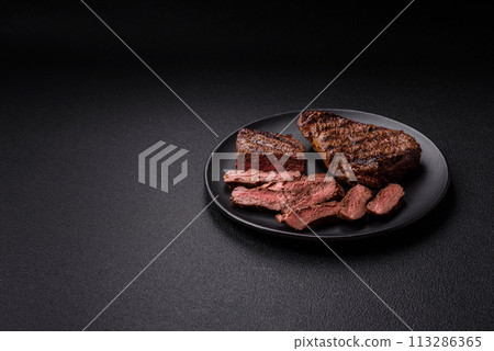 Fresh juicy delicious beef steak on a dark background 113286365