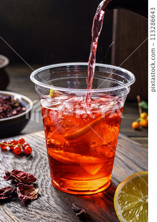Hibiscus tea pouring. Herbal tea made from crimson calyces of roselle flower Hibiscus tea pouring. Herbal tea made from crimson calyces of roselle flower 113286643