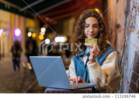Girl using credit bank card laptop transferring money drinking coffee purchases online shopping Girl using credit bank card laptop transferring money drinking coffee purchases online shopping 113286746