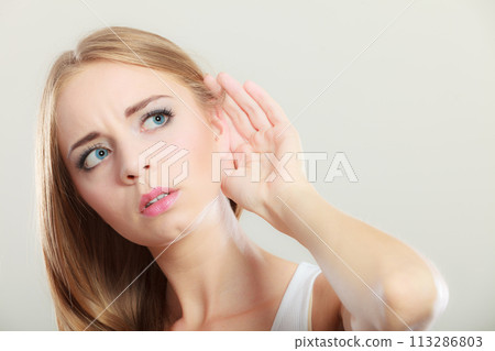 Woman with hand behind ear spying Woman with hand behind ear spying 113286803