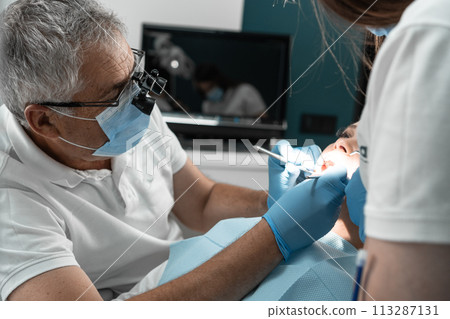 A dental assistant not only supports him in the treatment process, but also takes care of the patient's comfort, creating an atmosphere of trust and support. The teamwork of the doctor and assistant A dental assistant not only supports him in the treatment process, but also takes care of the patient's comfort, creating an atmosphere of trust and support. The teamwork of the doctor and assistant 113287131