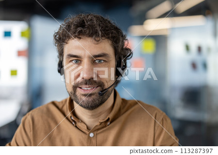 Professional male customer support representative wearing a headset, with a confident smile in a modern office setting. Professional male customer support representative wearing a headset, with a confident smile in a modern office setting. 113287397