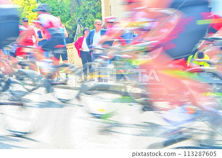 Abstract arty background: motion blur of bicycle racers competing on city streets. Tour of cycling. Blurry background sport with cyclists 113287605