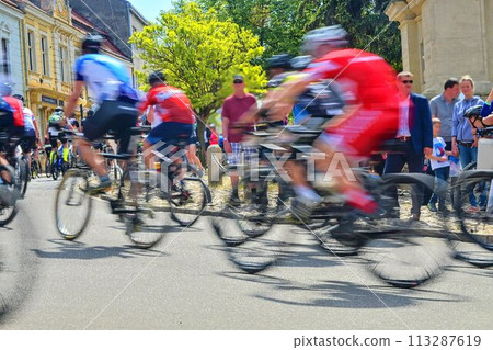Abstract arty background: motion blur of bicycle racers competing on city streets. Tour of cycling. Blurry background sport with cyclists Abstract arty background: motion blur of bicycle racers competing on city streets. Tour of cycling. Blurry background sport with cyclists 113287619