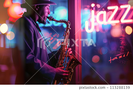 A jazz musician plays the saxophone in evening, against the backdrop of an illuminated neon "Jazz" sign. Jazz Appreciation Month, Club Life 113288139