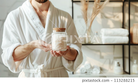 A close-up of a man's hands holding a jar of bath salts highlights a natural approach to health. Soft masculinity, daily self-care 113288215