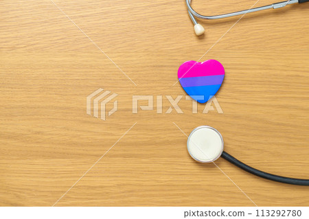 Bisexuality Celebrate Day and LGBT pride month,  LGBTQ+ or LGBTQIA+ concept. Stethoscope with purple, pink and blue heart shape for Lesbian, Gay, Bisexual, Transgender, Queer and Pansexual community 113292780