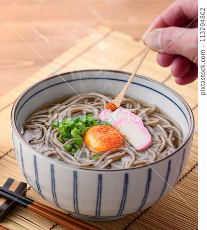 在月見蕎麥面上撒上七味 113294802