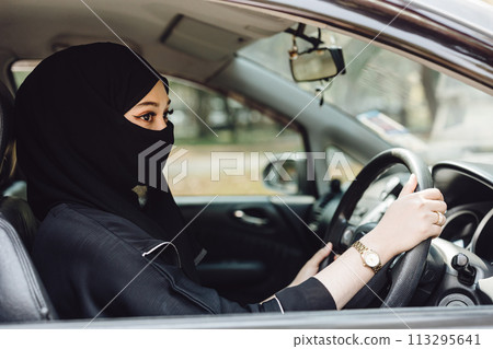 Saudi muslim women driving a car. Modern arab lady drive automotive vehicle. Saudi muslim women driving a car. Modern arab lady drive automotive vehicle. 113295641