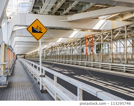 Warning sign 212-4 "Steep downhill slope ahead" installed on Rainbow Bridge; Yurikamome Line, which runs parallel to the bridge 113295746