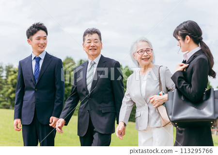 Senior and Gen Z businessmen and women in suits walking in the park Senior and Gen Z businessmen and women in suits walking in the park 113295766