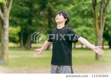 Young Asian man in sportswear taking deep breaths in the park (stretching, relaxing, refreshing) Young Asian man in sportswear taking deep breaths in the park (stretching, relaxing, refreshing) 113295804