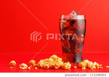 Cola with ice over red background Cola with ice over red background 113296801