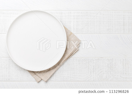 Empty plate on wooden table, overhead view 113296826