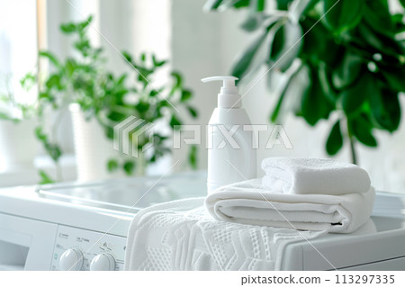 Stack of clean towels on modern washing machine with blurred background. The towels showcasing their soft and fluffy 113297335