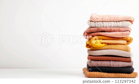 Pile of knitted sweaters and cozy scarves on solid background with copy space, Stack of clothes Pile of knitted sweaters and cozy scarves on solid background with copy space, Stack of clothes 113297342