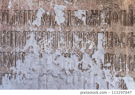 Ancient religious inscriptions on a dilapidated stone wall. Background, Texture for Design. High quality photo Ancient religious inscriptions on a dilapidated stone wall. Background, Texture for Design. High quality photo 113297847