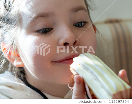 A little girl looks at a cake and wants to eat it. High quality photo 113297864
