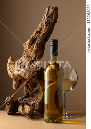 White wine and old snag on a beige background. 113298033