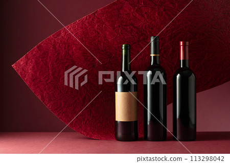 Bottles of red wine on a red background. Bottles of red wine on a red background. 113298042