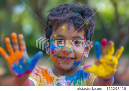A cute little smiling boy shows his painted hands to the camera during the Indian festival Holi 113298416