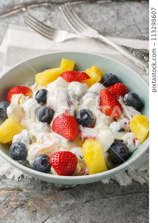 Delicious cheesecake fruit and berry salad with strawberries, blueberries, pineapple close-up in a bowl. Vertical Delicious cheesecake fruit and berry salad with strawberries, blueberries, pineapple close-up in a bowl. Vertical 113298607