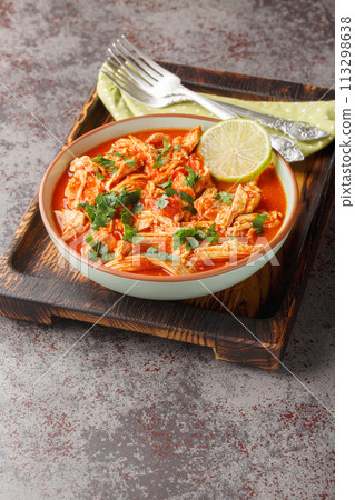 Crock Pot Salsa Chicken with taco seasoned pulled chicken breasts and tomato salsa close-up in a bowl. Vertical 113298638