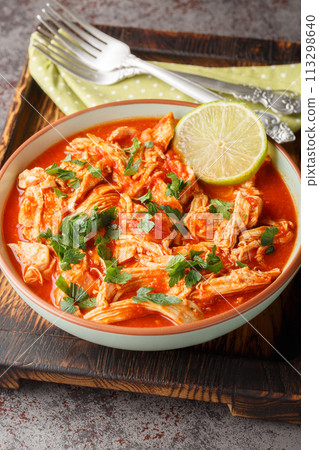 Salsa chicken combines taco seasoned chicken breasts with tomato salsa close-up in a bowl. Vertical 113298640