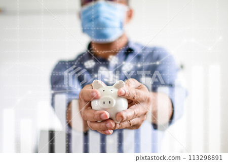 Close-up man holding a white pig piggy bank. Concept of men wearing a face mask to collect money during COVID-19 or coronavirus outbreak and investment budget wealth business. Blurred white background Close-up man holding a white pig piggy bank. Concept of men wearing a face mask to collect money during COVID-19 or coronavirus outbreak and investment budget wealth business. Blurred white background 113298891