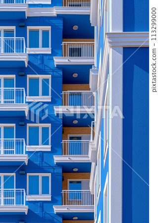 Vibrant blue apartment building with white balconies and wooden elements 113299000