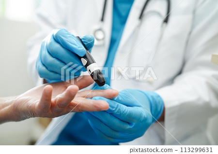 Asian doctor using lancet pen on senior patient finger for check sample blood sugar level to treatment diabetes. 113299631