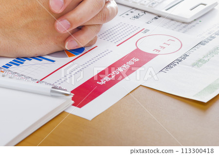 Image of considering and reviewing medical insurance and life insurance Image of considering and reviewing medical insurance and life insurance 113300418