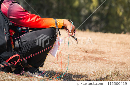 Paraglider on the ground. paragliders with full flight equipment look on soaring another paragliders at "Wat Pha Tak Suea" temple in nong khai thailand , Landscape from Beautiful View Mekong River. 113300419