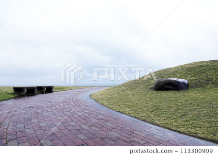 Benches and stones in a seaside park 113300909