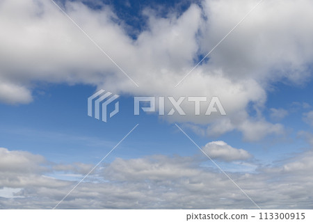 Textured cloud blanket breaks, revealing blue sky stretching towards the horizon for art 113300915