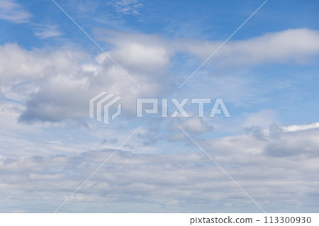 Tranquil light blue sky with textured cumulus clouds stretching to horizon 113300930