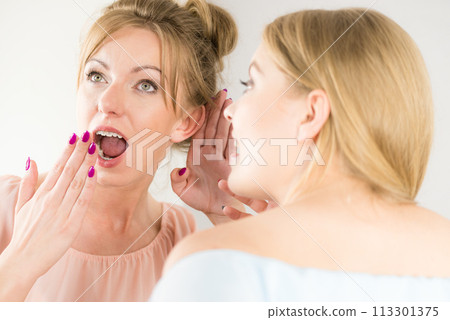 Two teen women gossiping 113301375