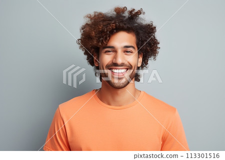 A man with curly hair is smiling and wearing an orange shirt A man with curly hair is smiling and wearing an orange shirt 113301516