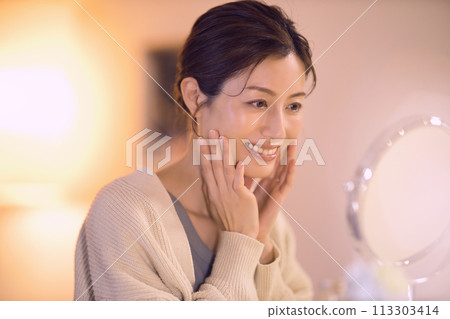 Middle-aged woman doing night skin care Middle-aged woman doing night skin care 113303414