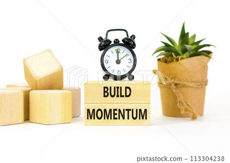 Build momentum symbol. Concept words Build momentum on wooden blocks. Beautiful white table white background. Black alarm clock. Business and build momentum concept. Copy space. 113304238