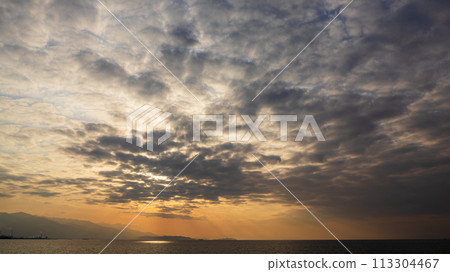 The setting sun and many clouds in the evening sky The setting sun and many clouds in the evening sky 113304467