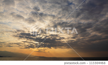 The setting sun and many clouds in the evening sky 113304468
