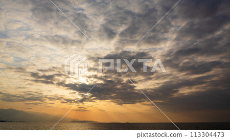 夕陽在傍晚的天空和許多雲彩中落下 113304473