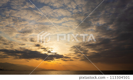 The setting sun and many clouds in the evening sky The setting sun and many clouds in the evening sky 113304501